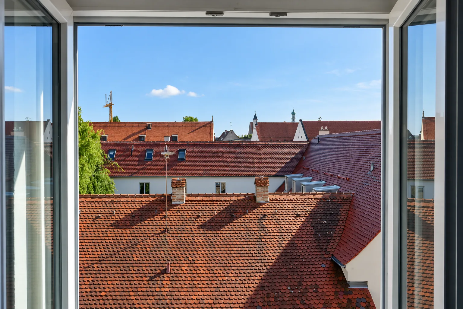 Blick aus dem Fenster einer Ferienwohnung über die Dächer der Augsburger Altstadt